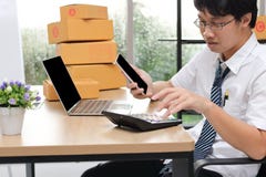 Young Asian entrepreneur owner chatting on phone at workplace at home. Start up small business stock image Young Asian entrepreneur owner chatting on phone at workplace at home. Start up small business stock image