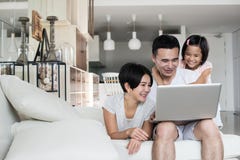 Young Asian family using a laptop together at home. royalty free stock images Young Asian family using a laptop together at home. royalty free stock images