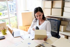 Young asian girl is freelancer Start up small business owner writing address on cardboard box at workplace,Shipping shopping stock images Young asian girl is freelancer Start up small business owner writing address on cardboard box at workplace,Shipping shopping stock images