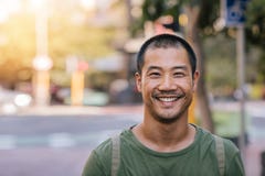 Young Asian man smiling confidently on a city street stock image Young Asian man smiling confidently on a city street stock image