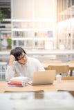 Young Asian man university student working in library stock images Young Asian man university student working in library stock images