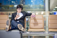 Young Asian businessman using smartphone in airport terminal Royalty Free Stock Image Young Asian businessman using smartphone in airport terminal Royalty Free Stock Image