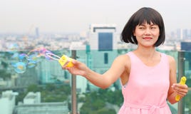 Young asian woman playing bubble on the roof top of building royalty free stock image Young asian woman playing bubble on the roof top of building royalty free stock image