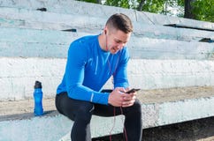 A young athlete sits in the stands and listens to music after training stock photos A young athlete sits in the stands and listens to music after training stock photos