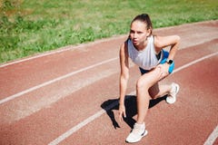 Young athletic girl athlete preparing to run at stadium, outdoors. The concept of healthy lifestyle royalty free stock image Young athletic girl athlete preparing to run at stadium, outdoors. The concept of healthy lifestyle royalty free stock image