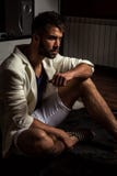 Young attractive bearded men in white suit pose in modern room. royalty free stock photography Young attractive bearded men in white suit pose in modern room. royalty free stock photography