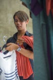 Young attractive and cool Asian man clothing store owner or employee working at beauty fashion shop organizing garment in business stock images Young attractive and cool Asian man clothing store owner or employee working at beauty fashion shop organizing garment in business stock images