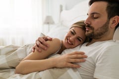 Young attractive couple having romantic time in bed stock image Young attractive couple having romantic time in bed stock image