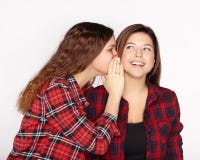 Young attractive girl whispering in the ear of his sister stock photography Young attractive girl whispering in the ear of his sister stock photography