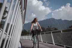 Young attractive woman with bicycle on a bridge royalty free stock image Young attractive woman with bicycle on a bridge royalty free stock image