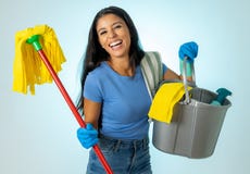 Young attractive woman holding cleaning tools and products in bucket on blue background royalty free stock photo Young attractive woman holding cleaning tools and products in bucket on blue background royalty free stock photo
