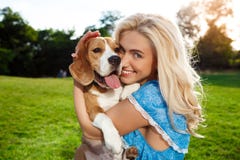 Young Beautiful Blonde Girl Walking, Playing With Beagle Dog In Park. Royalty Free Stock Photography Young Beautiful Blonde Girl Walking, Playing With Beagle Dog In Park. Royalty Free Stock Photography
