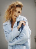 Young beautiful blonde woman posing in blue coat outdoors stock image Young beautiful blonde woman posing in blue coat outdoors stock image