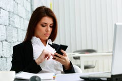 Young beautiful businesswoman typing on her smartphone Stock Image Young beautiful businesswoman typing on her smartphone Stock Image