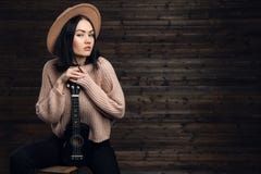 Young beautiful caucasian woman in casual playing small guitar royalty free stock photography Young beautiful caucasian woman in casual playing small guitar royalty free stock photography