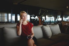 Young beautiful female entrepreneur talking on mobile smart phone while sitting with glass of fresh water in modern restaurant, royalty free stock photo Young beautiful female entrepreneur talking on mobile smart phone while sitting with glass of fresh water in modern restaurant, royalty free stock photo