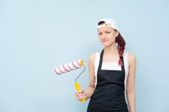 Girl painter, designer and worker paints a roller and brush the wall. Royalty Free Stock Image Girl painter, designer and worker paints a roller and brush the wall. Royalty Free Stock Image