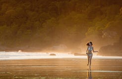 Young beautiful girl running on a beach in the morning mist. royalty free stock photography Young beautiful girl running on a beach in the morning mist. royalty free stock photography