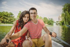 Young beautiful happy loving couple rowing a small boat on a lake. A fun date in nature. Couple in a boat. stock photos Young beautiful happy loving couple rowing a small boat on a lake. A fun date in nature. Couple in a boat. stock photos