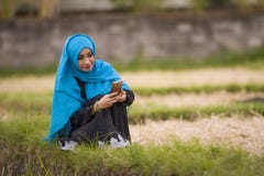 Young beautiful and happy muslim woman wearing islamic hijab head scarf and traditional clothing using internet app on mobile phon royalty free stock photos Young beautiful and happy muslim woman wearing islamic hijab head scarf and traditional clothing using internet app on mobile phon royalty free stock photos