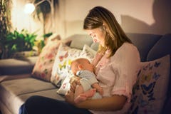 Young beautiful mother, breastfeeding her newborn baby boy stock photography Young beautiful mother, breastfeeding her newborn baby boy stock photography