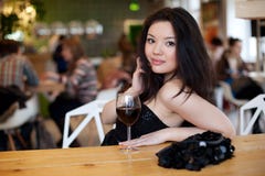 Young beautiful trendy woman in bar. Beautiful Asian girl in a p