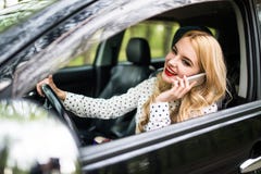 Young beautiful woman calling phone while driving car on street stock photos Young beautiful woman calling phone while driving car on street stock photos