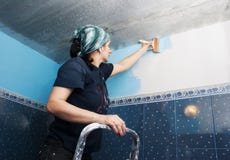 Young Beautiful Woman Paints The Wall Royalty Free Stock Photography Young Beautiful Woman Paints The Wall Royalty Free Stock Photography