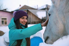 A young beautiful woman strokes a horse and smiles. royalty free stock images A young beautiful woman strokes a horse and smiles. royalty free stock images