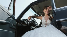 Young Beautiful Woman In Wedding Dress Posing In Vintage Car.