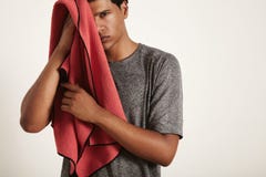 Young black sportsman wiping his face with a towel royalty free stock photography Young black sportsman wiping his face with a towel royalty free stock photography