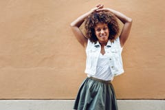 Young black woman, afro hairstyle, smiling in urban background stock photography Young black woman, afro hairstyle, smiling in urban background stock photography