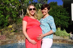 Young Blond Pregnant Woman With Her Friend By The Pool. Stock Photos