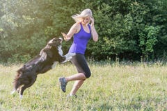 Young blond woman is running with her dog stock photography Young blond woman is running with her dog stock photography