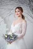 A young blonde bride in white wedding dress on a background of white walls and white tree in the background Stock Photos A young blonde bride in white wedding dress on a background of white walls and white tree in the background Stock Photos