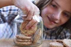 Young Boy Eating A Cookie From The Jar Royalty Free Stock Photos