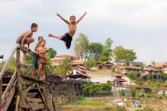 Young boy jumping into lake on Wooden bridge stock photography Young boy jumping into lake on Wooden bridge stock photography