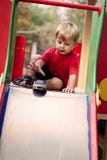Young Boy Playing with Toy Car on Slide royalty free stock images Young Boy Playing with Toy Car on Slide royalty free stock images