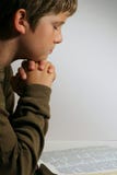 Young Boy Praying Over The Bible Stock Images