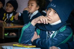 A Young Boy Sitting in School Looking Bored