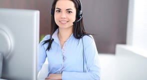 Young brunette business woman looks like a student girl working in office. Hispanic or latin american girl talking by royalty free stock photo Young brunette business woman looks like a student girl working in office. Hispanic or latin american girl talking by royalty free stock photo