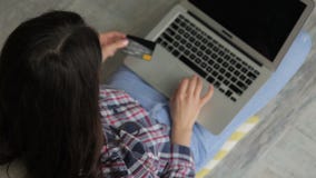 Young brunette pays for purchases with bank card at online store. stock video footage Young brunette pays for purchases with bank card at online store. stock video footage