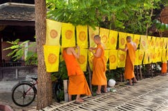 Young buddhist monks making daily work in garden of temple with festive flags Stock Photos Young buddhist monks making daily work in garden of temple with festive flags Stock Photos