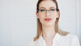 Young business lady in white shirt and glasses. Attractive young woman smiling royalty free stock photography Young business lady in white shirt and glasses. Attractive young woman smiling royalty free stock photography