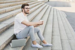Young businessman having rest with coffee outdoors stock photography Young businessman having rest with coffee outdoors stock photography