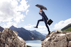 Businessman with umbrella jumping on mountains. royalty free stock photo Businessman with umbrella jumping on mountains. royalty free stock photo