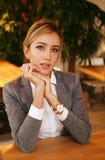Young businesswoman sitting at desk and working. Smiling and looking at camera. Lifestyle, people and business concept. Royalty Free Stock Image Young businesswoman sitting at desk and working. Smiling and looking at camera. Lifestyle, people and business concept. Royalty Free Stock Image