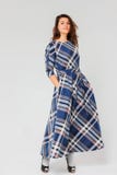 Young Charming Brunette Woman With Curly Hair In Long Plaid Blue Dress Stock Photo