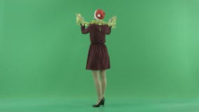 A young Christmas woman is circling under the snowfall on the green screen stock footage A young Christmas woman is circling under the snowfall on the green screen stock footage