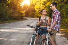 Young couple biking on a forest road in a sammer day stock photo Young couple biking on a forest road in a sammer day stock photo